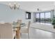 Elegant dining area featuring a chandelier, table setting, and balcony access with city views at 6 Belleview Blvd # 706, Belleair, FL 33756