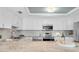 Bright kitchen featuring white cabinets, granite countertops, and stainless steel appliances at 6 Belleview Blvd # 706, Belleair, FL 33756