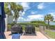 Water view from the patio that features two Weber grills, a table and chairs, with some palm trees at 6 Belleview Blvd # 706, Belleair, FL 33756