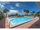 Inviting outdoor pool area surrounded by brick patio, palm trees, and seating, with views of the water at 6 Belleview Blvd # 706, Belleair, FL 33756