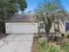 Charming home featuring a manicured lawn, a front garage, and a beautiful palm tree at 7518 Clanton Trl, Hudson, FL 34667