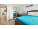 Bedroom with teal bedding, wood frame bed, and mirrored closet at 7518 Clanton Trl, Hudson, FL 34667