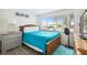 Bedroom with teal bedding, wood frame bed, and window view at 7518 Clanton Trl, Hudson, FL 34667