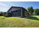 House exterior showcasing screened porch and landscaping at 13600 Ponce De Leon Blvd, Brooksville, FL 34601