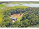 Aerial view of home near a lake and dense vegetation at 13600 Ponce De Leon Blvd, Brooksville, FL 34601