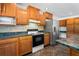 Kitchen with stove, microwave, and stainless steel refrigerator at 13600 Ponce De Leon Blvd, Brooksville, FL 34601
