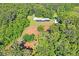 Aerial view of house nestled in a wooded area with cleared land at 13600 Ponce De Leon Blvd, Brooksville, FL 34601