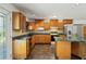 Galley kitchen with wood cabinets and granite countertops at 13600 Ponce De Leon Blvd, Brooksville, FL 34601