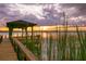 Serene lakeside dock with gazebo at sunset at 4300 Wheatland Way, Palm Harbor, FL 34685