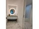 Modern bathroom featuring marble floors, floating vanity with round illuminated mirror, and bathtub at 777 3Rd N Ave # 908, St Petersburg, FL 33701
