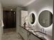 Modern bathroom featuring double sinks, illuminated mirrors, and a glass-enclosed shower at 777 3Rd N Ave # 908, St Petersburg, FL 33701