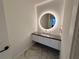 Bathroom vanity features a unique round LED mirror and sleek gray countertop at 777 3Rd N Ave # 908, St Petersburg, FL 33701