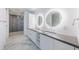Contemporary bathroom with a double sink vanity, illuminated mirrors, modern cabinetry, and a glass-enclosed shower at 777 3Rd N Ave # 908, St Petersburg, FL 33701