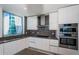 Contemporary kitchen featuring stainless steel appliances, gray countertops, and white cabinets at 777 3Rd N Ave # 908, St Petersburg, FL 33701