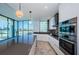 This contemporary kitchen has an expansive island, gray counters, stainless appliances and floor to ceiling windows at 777 3Rd N Ave # 908, St Petersburg, FL 33701