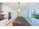 A modern kitchen with gray countertops, stainless appliances and views of the city skyline and lake at 777 3Rd N Ave # 908, St Petersburg, FL 33701