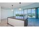 A modern kitchen island with gray countertops and views of the city from floor to ceiling windows at 777 3Rd N Ave # 908, St Petersburg, FL 33701