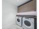 Well-lit laundry room with modern washer and dryer and sleek overhead storage at 777 3Rd N Ave # 908, St Petersburg, FL 33701