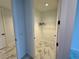Bright walk-in closet with white wire shelving and modern marble-look tile flooring at 777 3Rd N Ave # 908, St Petersburg, FL 33701