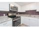 Updated kitchen with white cabinets, granite countertops, and stainless steel appliances at 2462 Brazilia Dr # 38, Clearwater, FL 33763