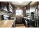 Modern kitchen with dark wood cabinets, granite countertops, and stainless steel appliances at 18399 Gulf Blvd # 372, Indian Shores, FL 33785