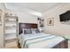 Cozy bedroom with a queen-size bed, built-in shelves, and a TV at 18399 Gulf Blvd # 372, Indian Shores, FL 33785