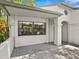 White exterior with a covered entryway and large window at 3856 Goldfinch Ct, Palm Harbor, FL 34685