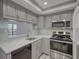 Updated kitchen with gray cabinets, stainless steel appliances, and quartz countertops at 400 Island Way # 308, Clearwater, FL 33767