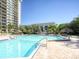 Inviting community pool with lounge chairs and umbrellas at 400 Island Way # 308, Clearwater, FL 33767