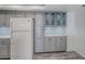 Kitchen boasts ample storage with gray cabinets and glass-front upper cabinets at 400 Island Way # 308, Clearwater, FL 33767