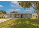 Gray house with black door and green lawn at 6840 Runnel Dr, New Port Richey, FL 34653