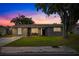 Inviting curb appeal with landscaping and twilight view at 6840 Runnel Dr, New Port Richey, FL 34653