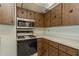 Kitchen with wood cabinets, microwave, and stove at 6087 16Th Ne Ln, St Petersburg, FL 33703