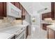 Kitchen with white appliances and dark wood cabinets at 1 Seaside Ln # 104, Belleair, FL 33756