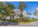 Luxury condo building with lush landscaping and palm trees at 1 Seaside Ln # 104, Belleair, FL 33756
