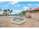 Inviting pool area with hot tub, lounge chairs, and patio tables at 7537 Bayshore Dr # 303, Treasure Island, FL 33706