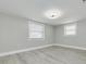 Spacious bedroom with two windows and grey wood-look flooring at 9124 Lido Ln, Port Richey, FL 34668