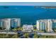 Aerial view of Island Towers complex overlooking the water with palm trees and lush landscape at 300 Woodette Dr # 202B, Dunedin, FL 34698