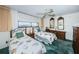 Cozy bedroom featuring twin beds with floral bedding, ceiling fan and a window view at 300 Woodette Dr # 202B, Dunedin, FL 34698