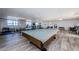 Large game room features a covered pool table, ping pong table, and weightlifting equipment for diverse recreational activities at 300 Woodette Dr # 202B, Dunedin, FL 34698