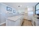 Clean and well-maintained kitchen with an island, bright white cabinetry, and matching appliances at 300 Woodette Dr # 202B, Dunedin, FL 34698