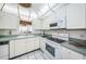 Bright kitchen with white cabinets, appliances, and a window over the sink at 300 Woodette Dr # 202B, Dunedin, FL 34698