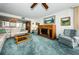 Inviting living room featuring a wooden entertainment center, comfortable seating, and green carpeting at 300 Woodette Dr # 202B, Dunedin, FL 34698