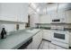Kitchen with white cabinets, appliances, and green countertops at 300 Woodette Dr # 202B, Dunedin, FL 34698