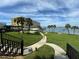 Well-maintained lawn with palm trees and a walkway leading to waterfront at 100 Bluff View Dr # 208B, Belleair Bluffs, FL 33770