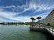 View of waterfront with building and palm trees at 100 Bluff View Dr # 208B, Belleair Bluffs, FL 33770
