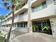 Main building entrance with steps and lush landscaping at 100 Bluff View Dr # 208B, Belleair Bluffs, FL 33770