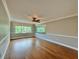 Bedroom with hardwood floors, ceiling fan, and large mirror at 100 Bluff View Dr # 208B, Belleair Bluffs, FL 33770
