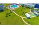 Aerial view showing lush landscaping, pool, and shuffleboard at 100 Bluff View Dr # 208B, Belleair Bluffs, FL 33770