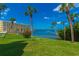Landscaped lawn with palm trees and beautiful waterfront views at 100 Bluff View Dr # 208B, Belleair Bluffs, FL 33770